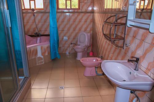 y baño con lavamanos, aseo y lavamanos. en Maison De Omashi, en Kigali