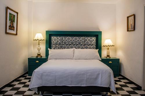 a bedroom with a bed with two night stands and two lamps at Casa Zepeda in Atlixco