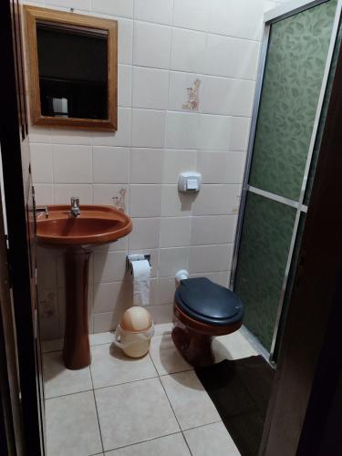 uma casa de banho com um lavatório, um WC e um chuveiro em Hotel Relvado em Relvado