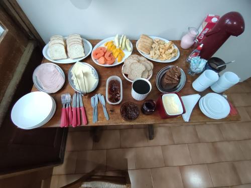 a table with plates of food and utensils at Hotel Relvado in Relvado