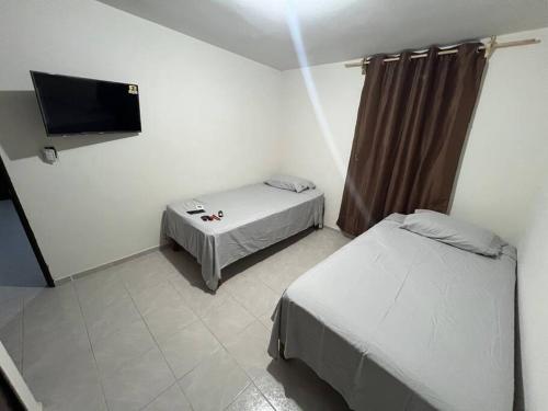 a small room with two beds and a flat screen tv at Departamento Doña Maryy in Tampico