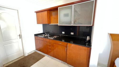 a kitchen with wooden cabinets and a black counter top at SharmStar in Sharm El Sheikh
