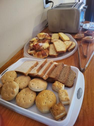 einen Tisch mit zwei Brotplatten und einem Teller Essen in der Unterkunft Posada del Musiquero in Cafayate