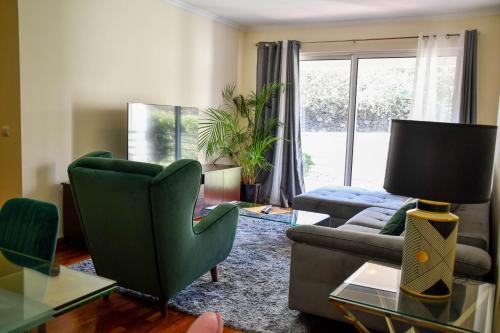 - un salon avec un canapé et une télévision dans l'établissement Tranquility Apartment, à Caniço