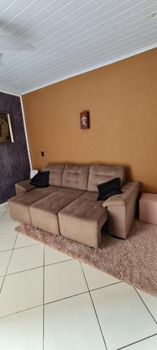 a living room with a large couch in a room at Rose House in Arraial do Cabo