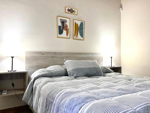 1 dormitorio con 1 cama con 2 lámparas y 2 cuadros en la pared en Cabañas Mágico Atardecer en San Rafael