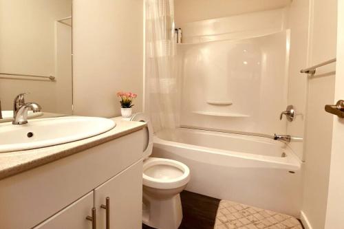 Baño blanco con lavabo y aseo en Afan Home of Joy en Winnipeg