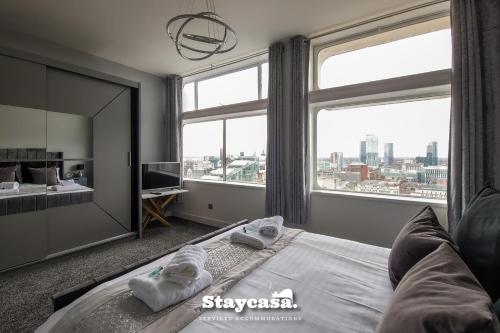 een slaapkamer met een bed en een groot raam bij Luxury 2bdr Penthouse On 23rd Floor With View in Manchester