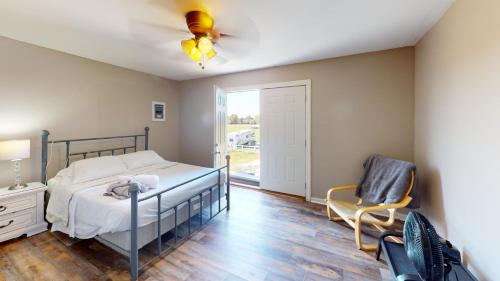 a bedroom with a bed and a chair at The Barn Apartment at Parkton Place in Hope Mills