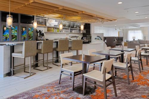 a restaurant with tables and chairs and a bar at Courtyard by Marriott Sarasota at University Town Center in Sarasota
