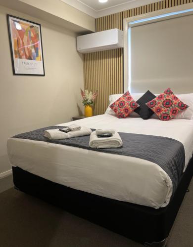 a bedroom with a large bed with towels on it at Comfort Inn Serenity Bathurst in Bathurst