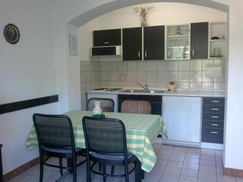 una cucina con tavolo, sedie e lavandino di Guest House Violeta a Rab