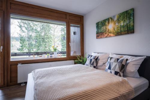 A bed or beds in a room at Auszeit Apartment BLACK FOREST EMOTION mit Sonnenbalkon mit Blick auf den Kurpark, schnelles Internet, Nähe Triberger Wasserfälle, für bis zu 2 Personen