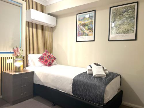a bedroom with a bed and a nightstand with towels on it at Comfort Inn Serenity Bathurst in Bathurst