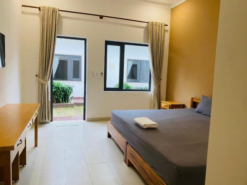 a bedroom with a bed and a large window at ARECA MUINE HOMESTAY in Phan Thiet