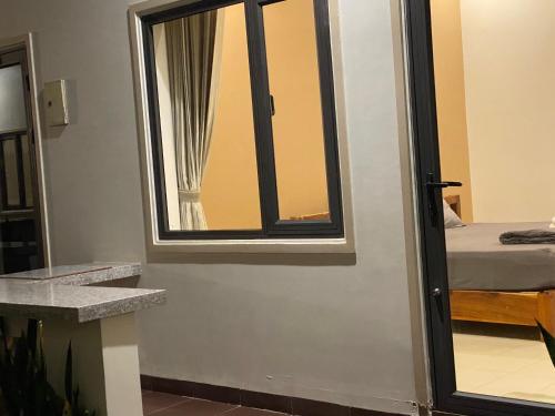 a room with a window and a bed and a mirror at ARECA MUINE HOMESTAY in Phan Thiet