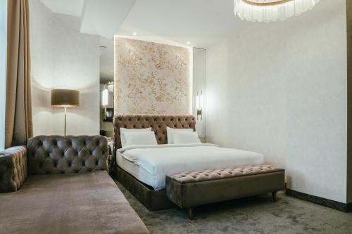 a bedroom with a large bed and a couch at Highgarden Hotel in Tbilisi City