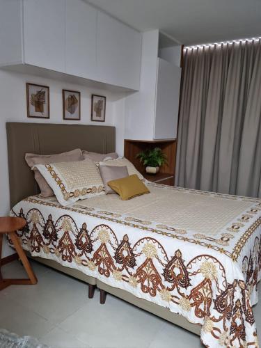 a bedroom with a large bed with a blanket on it at Studio Barra Premium in Salvador