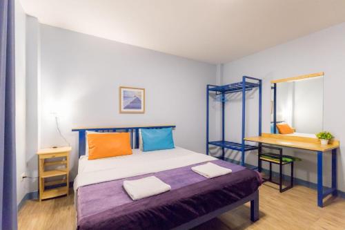 a small bedroom with a bed and a desk at Blueplace บลูเพลส in Ban Talat Rangsit