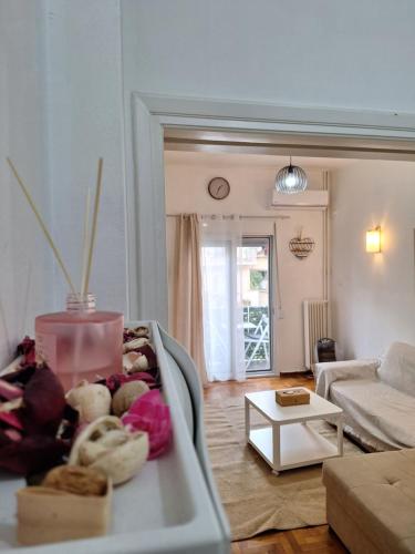 een woonkamer met een bank en een tafel bij Comfortable near metro by hospitality gr in Athene