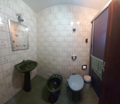 a bathroom with a green sink and a toilet at Edificio Daniela Ap 101 in Bombinhas