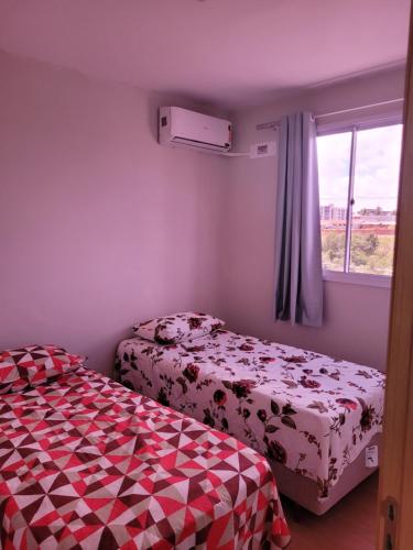 a small bedroom with a bed and a window at Residencial Jardim da costa in João Pessoa