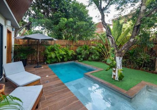 a small swimming pool in a backyard with a tree at Villa Paradise Tulum Veleta 4BR private pool & jacuzzi in Tulum