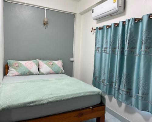 a bedroom with a bed with a blue shower curtain at หอพักบ้านชูใจ in Phitsanulok