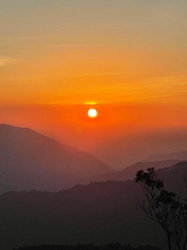 a sunset in the mountains with the sun in the sky at Junyi Landscape Villa in Renai