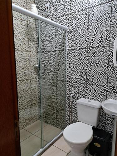ein Bad mit einem WC und einer Glasdusche in der Unterkunft Casa aconchego Parque Mambucaba in Angra dos Reis
