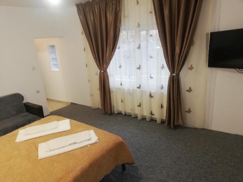 a room with a table and a couch and a window at Casa Bucur in Tîrgu Ocna