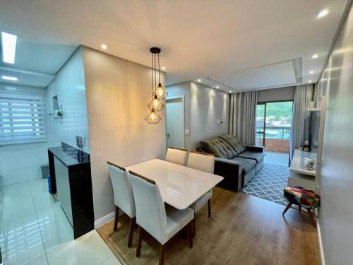 a dining room and living room with a table and chairs at Apartamento no Canto do Forte - Praia Grande in Praia Grande