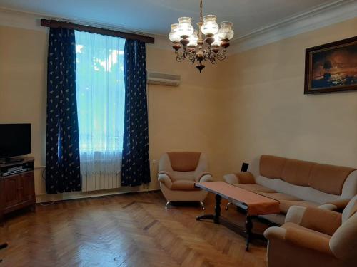 een woonkamer met een bank, stoelen en een tafel bij F1 Track View Balcony ZARIFA ALIEVA Street in Baku