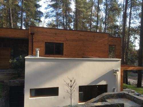ein kleines Haus mit einer weißen und braunen Fassade in der Unterkunft House & Lake rapel in Las Cabras