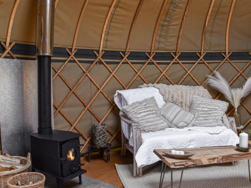 a room with a yurt with a couch and a stove at Little West View in Chard