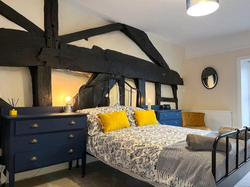 1 dormitorio con cama negra y almohadas amarillas en The Hideaway en Chapel en le Frith