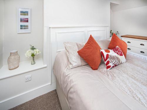 a white bedroom with a couch with pillows on it at Bishopfield House in Dornoch