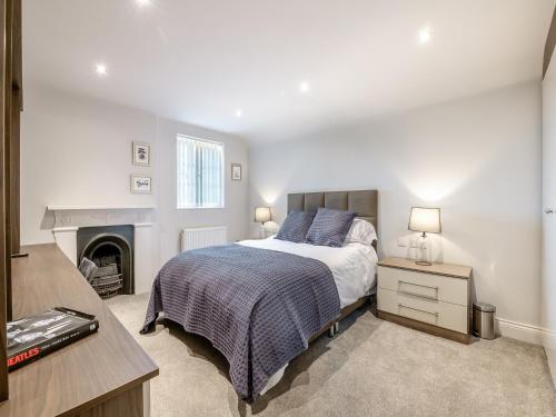 a bedroom with a bed and a fireplace at Foremans Cottage in Skidby