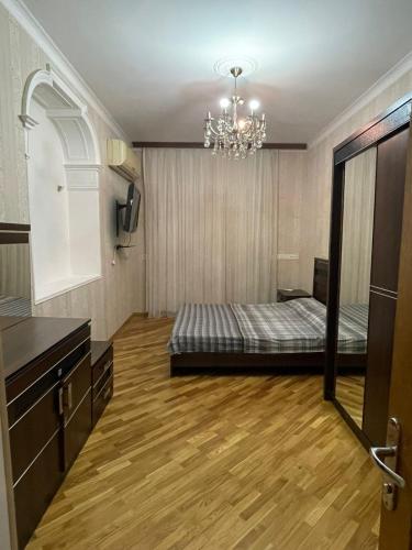 een slaapkamer met een bed en een kroonluchter bij F1 Track View Balcony ZARIFA ALIEVA Street in Baku