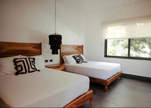 a bedroom with two beds and a window at New Villa 4BR private pool & jacuzzi TULUM Veleta in Tulum