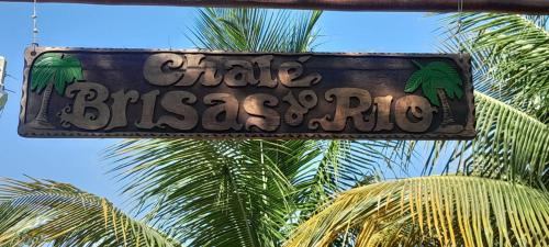 a sign for a bar with palm trees in the background at Chalé Brisas do Rio in Petrolina