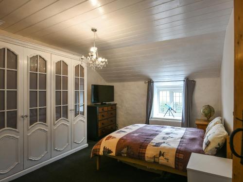 a bedroom with a bed and a window at Tir-y-coed in Gwernymynydd