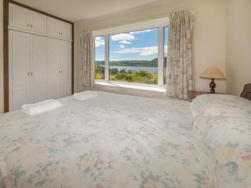 a bedroom with a large bed and a large window at Barr Beithe Upper in Dalavich