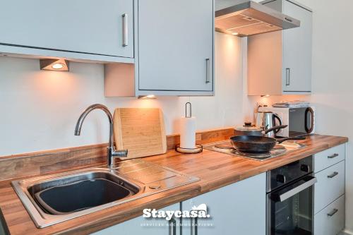 a kitchen with a sink and a microwave at Bright & Central Apt - With Great Transport Links in Stockport