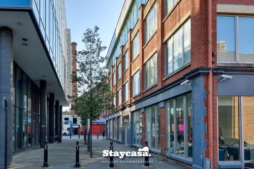 an empty street in a city with tall buildings at Bright & Central Apt - With Great Transport Links in Stockport