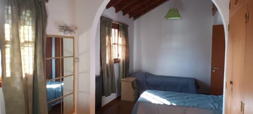 1 dormitorio con cama, ventana y puerta en Aljaba en Esquel