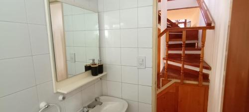 a white bathroom with a sink and a mirror at Aljaba in Esquel