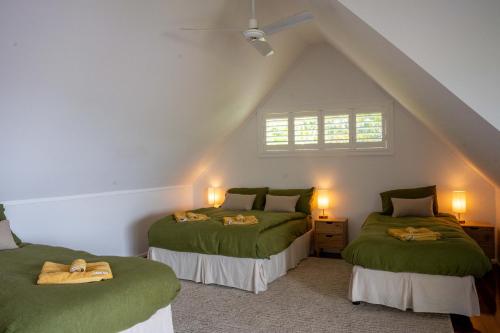 two green beds in a room with a attic at Serenity - Gold Coast hinterland getaway for a couple, family or group in Mount Tamborine