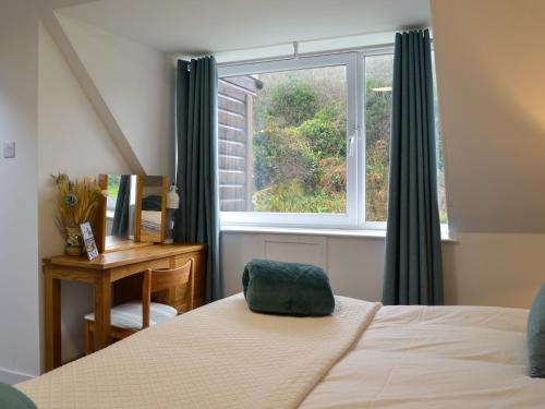 a bedroom with a bed and a window at Clachries Cottage in Boreland of Colvend