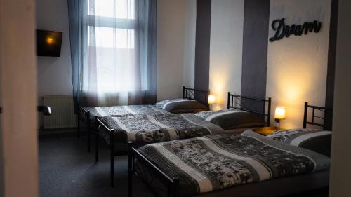 um grupo de quatro camas num quarto em Ferienwohnung zum alten Hotel em Gramzow